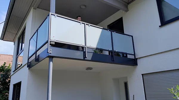 Bild_Leistungen_Balkone_1 Balkon mit Glasverkleidung an weißer Hausfassade