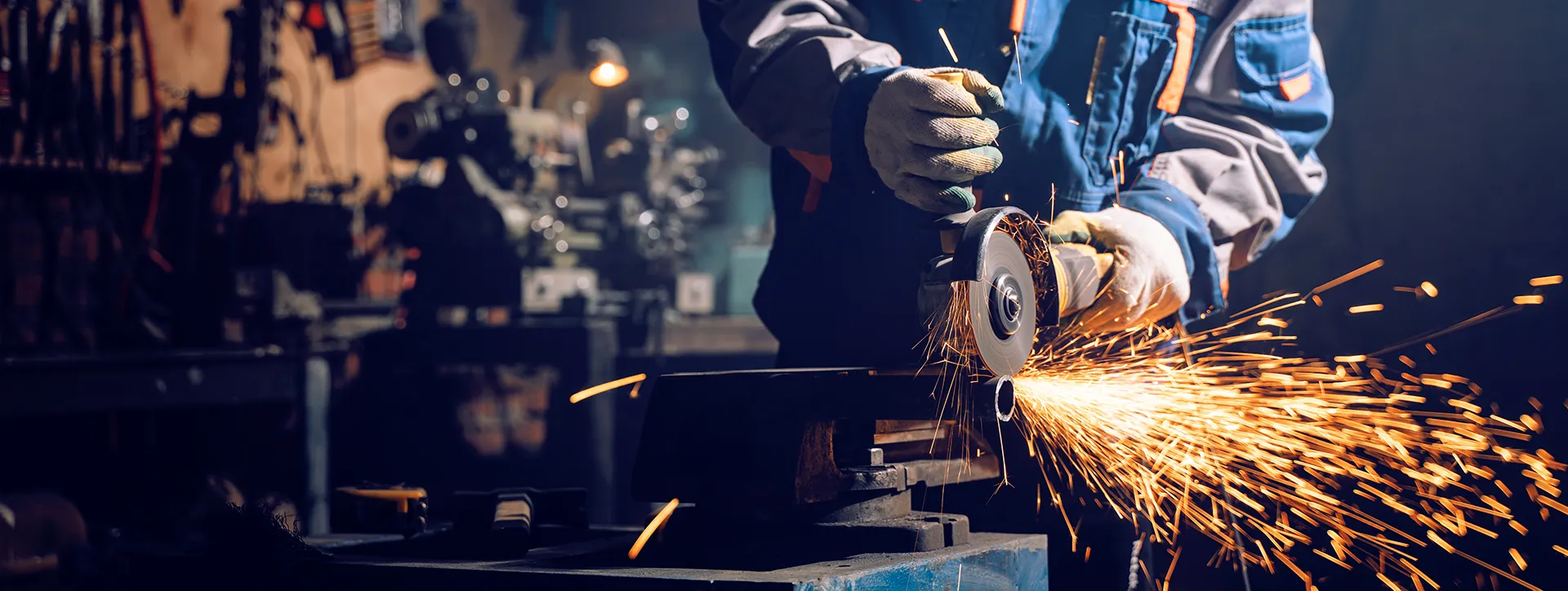 Blechner beim Bearbeiten von Metall mit einer Schleifmaschine mit Funken